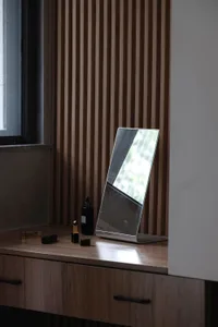 A modern office desk featuring a wooden surface with a sleek, minimalist design, placed in front of a window with natural lig
