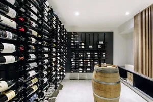 A modern wine cellar with a grid of steel shelves filled with bottles of wine.
