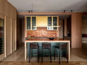 A modern kitchen featuring a kitchen island with a marble countertop and wooden stools.