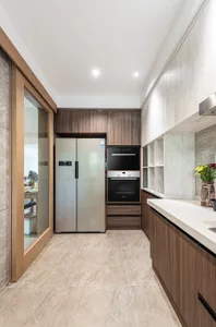 Modern kitchen featuring marble countertops, wood cabinetry, and stainless steel appliances.