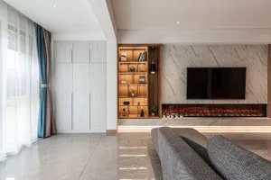 Modern living room featuring a marble fireplace and shelves with decorative items.