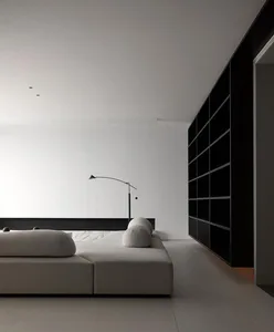 Modern living room with minimalist design, white walls, and a upholstered sofa.