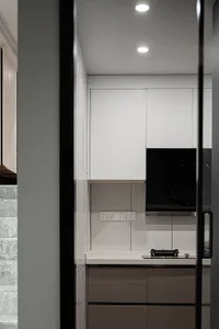Modern minimalist kitchen with white countertop, dark grey cabinets, and white upper cabinets.
