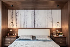 A modern residential bedroom with a wooden bed frame, blue sheets, and a forest mural on the wall.