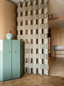 Living room featuring metallic cube wall and mint green cabinet