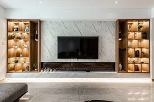 A modern home theater with marble accent wall and built-in shelving.