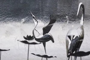 Metal bird sculptures with reflective surfaces.