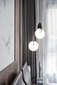 A minimalist bedroom featuring textured curtains hanging from the ceiling.