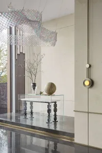 A modern entryway featuring marble, glass, and concrete materials.