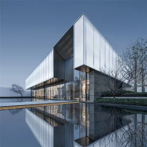 A modern building exterior with a glass facade reflecting the surrounding environment.