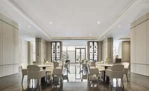Modern hotel lobby with marble countertops, leather chairs, and glass displays.