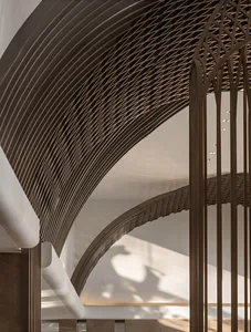 Modern interior design featuring a metallic mesh ceiling and curved lines.