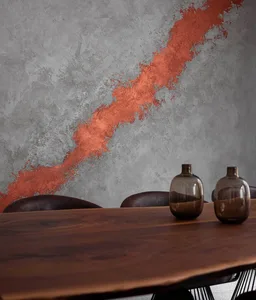Modern interior design featuring a wooden dining table against a textured red-orange and gray wall.