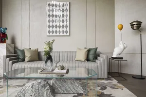 Modern living room with fabric sofa, glass coffee table, and wooden details.