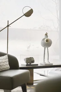 Modern minimalist living room with a sofa, coffee table, and decorative objects.