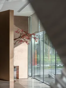 A modern office entryway featuring glass walls and marble columns.