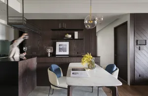 A modern residential kitchen featuring a marble countertop, wooden cabinets, and a stainless steel kitchen island.