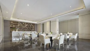A modern restaurant interior featuring elegant white marble finishes and sleek white furniture.