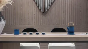 A sleek, minimalist tea ceremony space featuring wooden materials and contemporary blue accents.