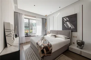 Modern minimalist bedroom featuring a grey upholstered bed with a geometric abstract painting above, white curtains, and a st