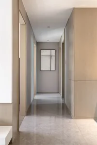 A minimalist floor corridor featuring a marble surface, viewed from the entrance towards the far end.