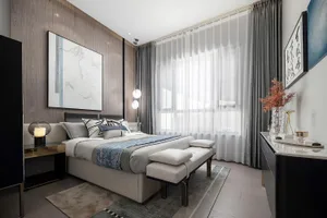 Contemporary bedroom with minimalist furniture, fabric bedding, and modern art.