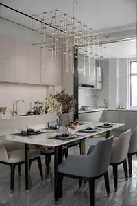 Modern dining area with marble table, glass chandelier, and metal chairs