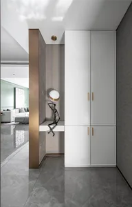 Modern residential entryway featuring gray marble flooring, white cabinets, and a white pendant light hanging above the seati