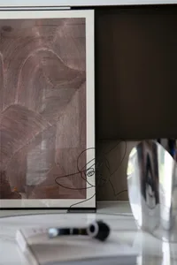A wire sculpture of a woman's face on a coffee table in a modern interior setting.