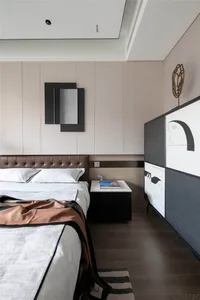 Modern bedroom featuring wooden flooring and fabric bedspread, with minimalist decor and a minimalist side table.