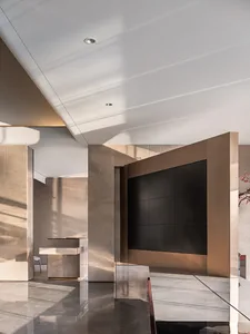 Modern lobby interior with metallic accent wall and reception desk.