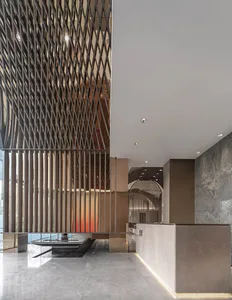 A modern lobby interior with metallic patterned walls and ceiling lights.
