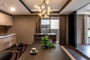 Modern residential dining space featuring wooden furniture and a marble countertop.