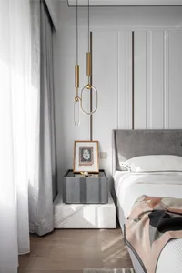 Modern minimalist bedroom featuring grey upholstered bed and marble nightstand with abstract artwork.