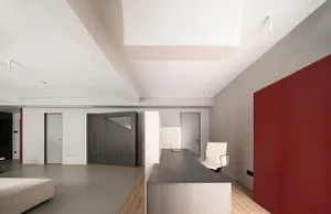 A modern industrial office space featuring exposed concrete floors and walls.