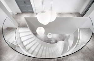 A minimalist staircase with a glass railing and concrete steps.