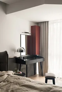 Modern bedroom featuring a wooden desk with a mirror and lamp, and a cozy fabric bed.