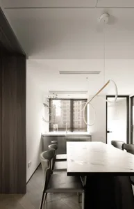Modern dining room featuring a white marble dining table and minimalist design with dark wooden accents and a Hanging Light F