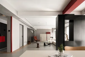 Minimalist living room with concrete walls, red accents, and modern furniture.