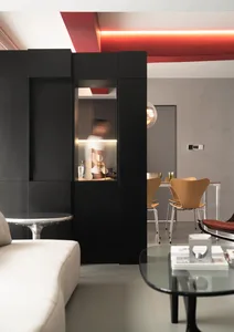 A modern living room featuring sleek furniture, a minimalist design, and a mix of metal, wood, and glass materials.
