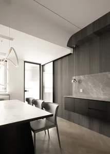Modern residential kitchen featuring a marble countertop and wooden flooring.