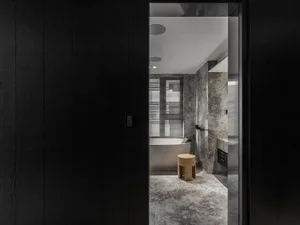 A modern bathroom with marble walls and floor, featuring a freestanding bathtub and minimalist design.