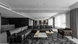 A modern living room featuring black leather furniture and minimalist decor.