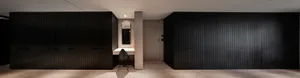 Minimalist office space featuring modern black-paneled walls