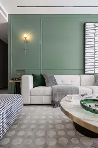 Modern living room featuring a textured white couch, patterned rug, and metallic coffee table.