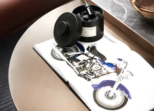 A black motorcycle accessory with metallic trim and a drawer containing charcoal.