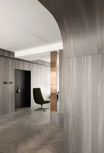 A modern home office with dark wood walls and a sleek, green swivel chair.