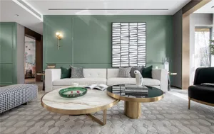 A modern living room featuring a white sofa, green accent wall, and metallic coffee table with books and a statue.