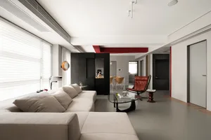 A minimalist living room with neutral-toned leather furniture and black metal accents.