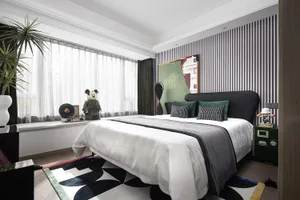 A modern bedroom interior with a white bed, green and black accents, and a striped wall.